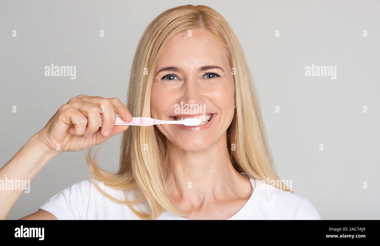 Oral hygiene concept. Middleaged woman brushing teeth Stock Photo Alamy
