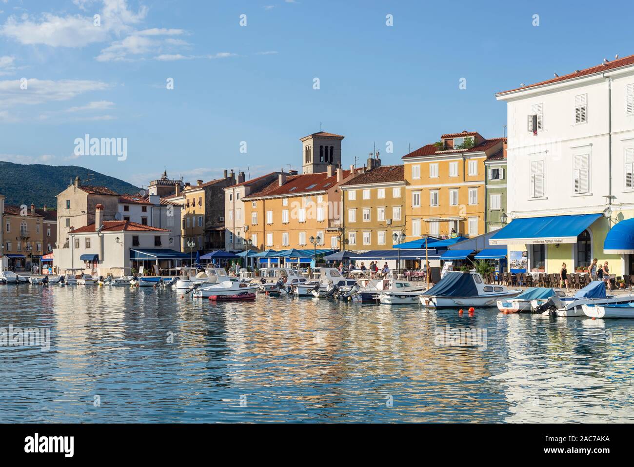 Motor boats, sailing boats and yachts in the harbor of the old town of Cres with cafes and restaurants in the evening sun, Cres, Kvarner Bay, Croatia Stock Photo