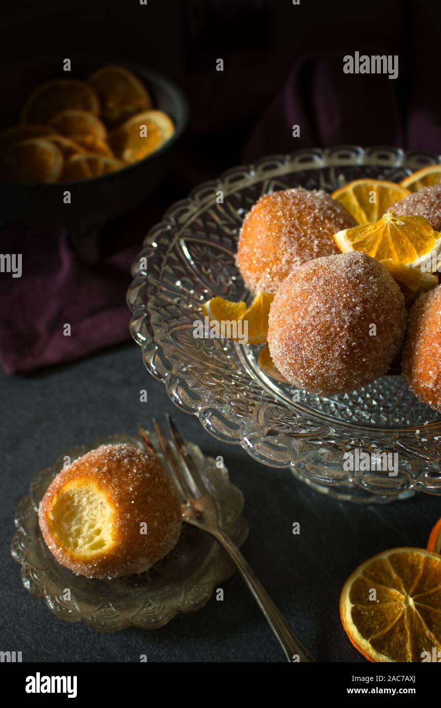 Dark and moody food photography of spiced orange donut holes with sugar Stock Photo