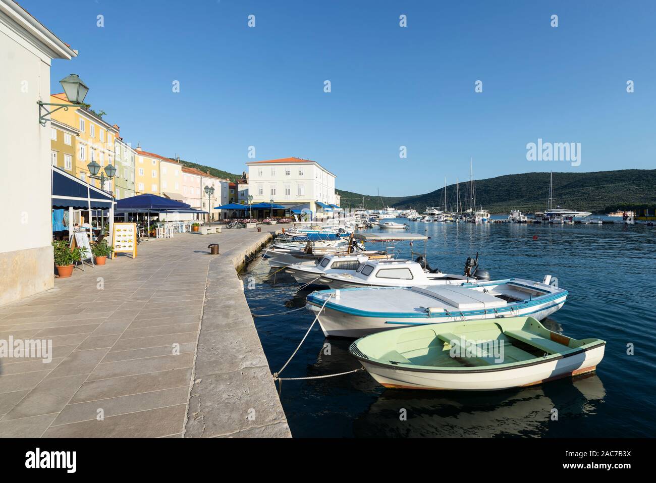 Motor boats, sailing boats and yachts in the harbor of the old town of Cres with cafes and restaurants in the evening sun, Cres, Kvarner Bay, Croatia Stock Photo