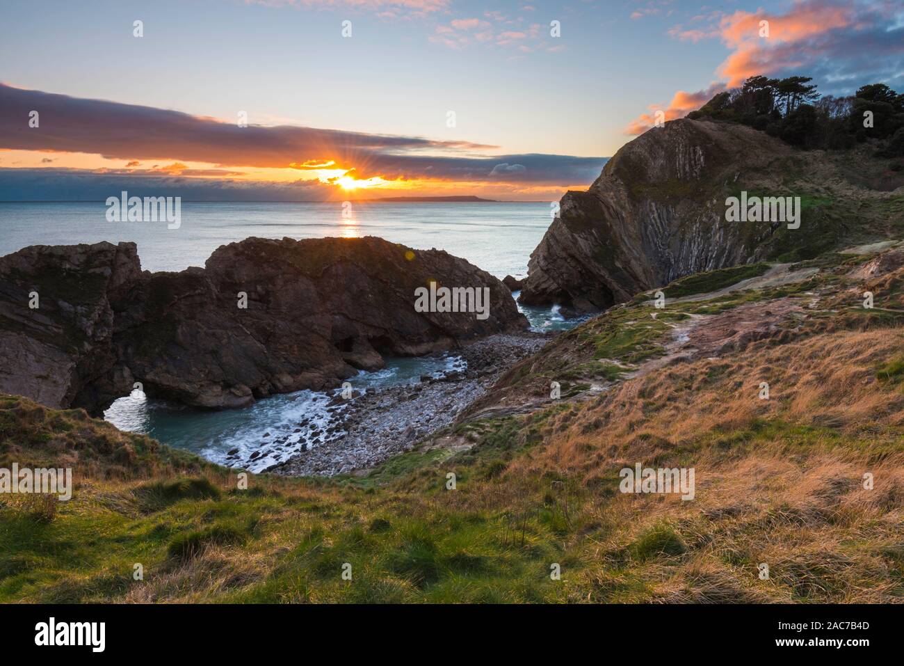 Lulworth, Dorset, UK. 1st Dec, 2019. UK Weather. Clouds building in the sky at sunset at Stair Hole at Lulworth in Dorset at the end of a cold sunny day on the first day of winter. Picture Credit: Graham Hunt/Alamy Live News Stock Photo