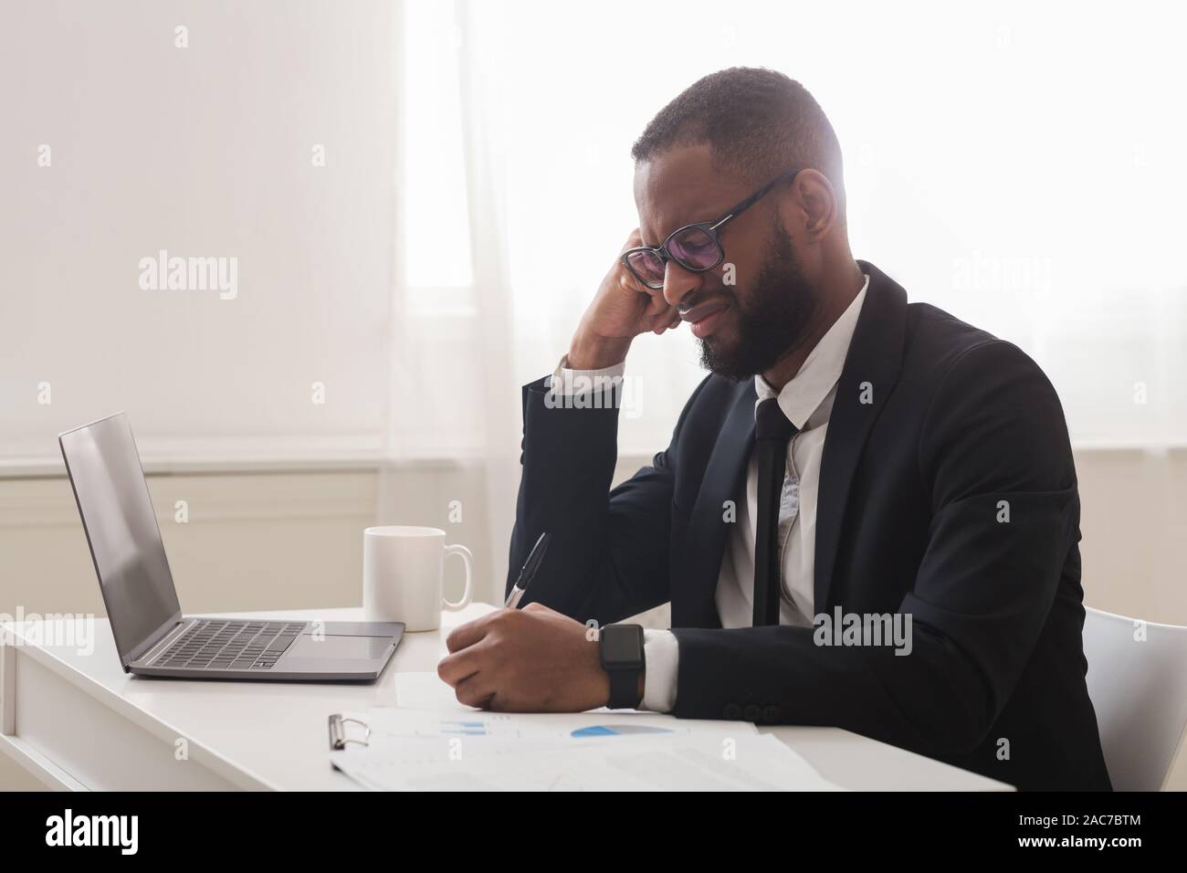 Exhausted entrepreneur working with documents in office Stock Photo