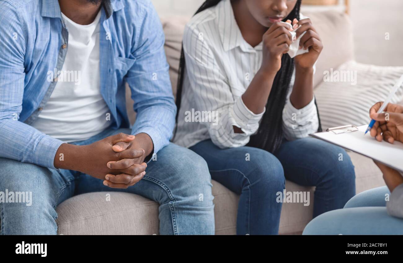 Unrecognizable Black Couple Sitting On Couch At Marital Counselor's Office Stock Photo