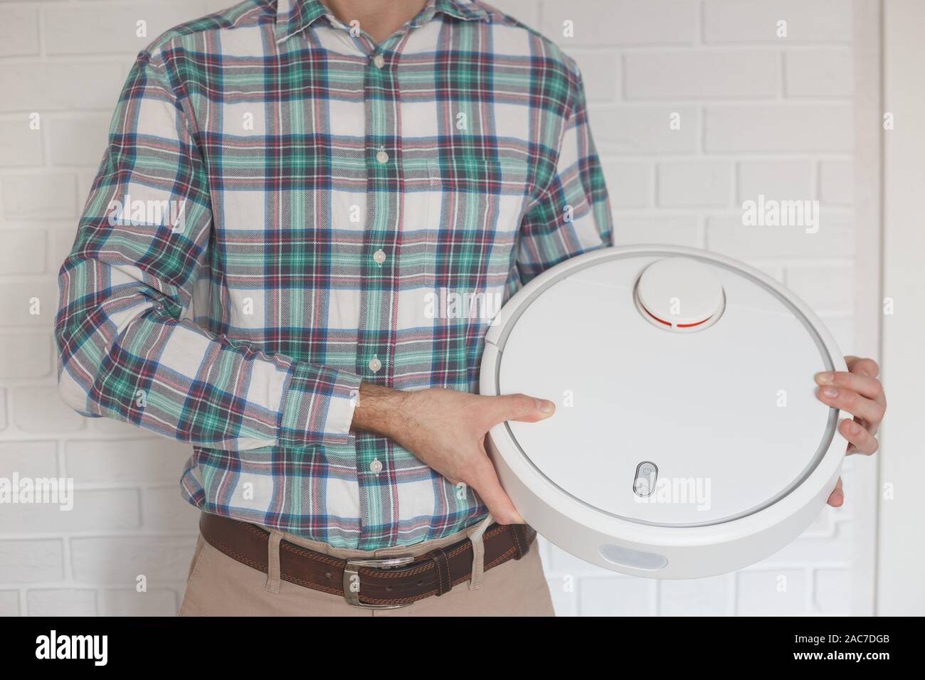 Man with a new robot with a vacuum cleaner in his hands Stock Photo