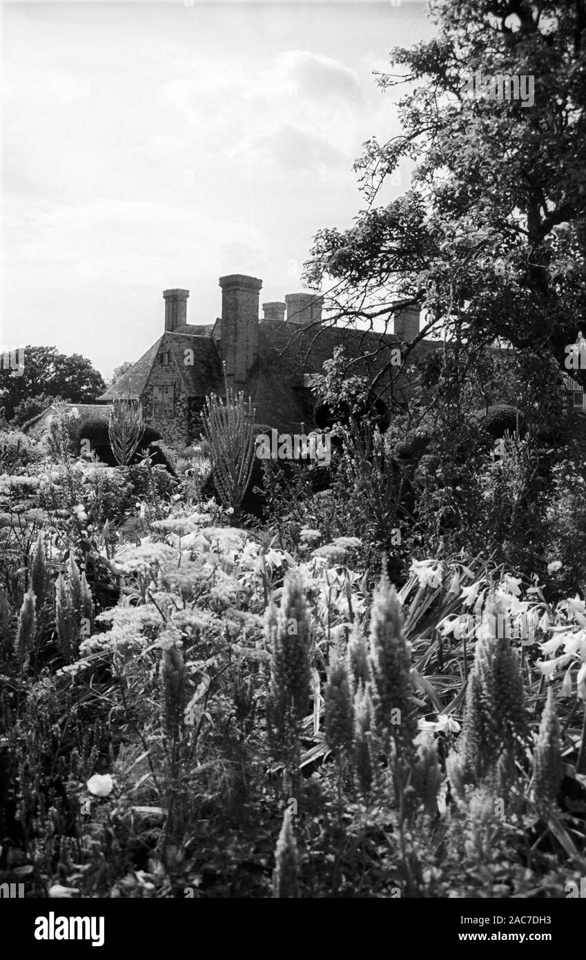 East wing of Great Dixter Manor, this part designed by Edwin Luytens, seen across part of Christopher Lloyd's High Garden.  Old black and white film photograph, circa 1980 Stock Photo