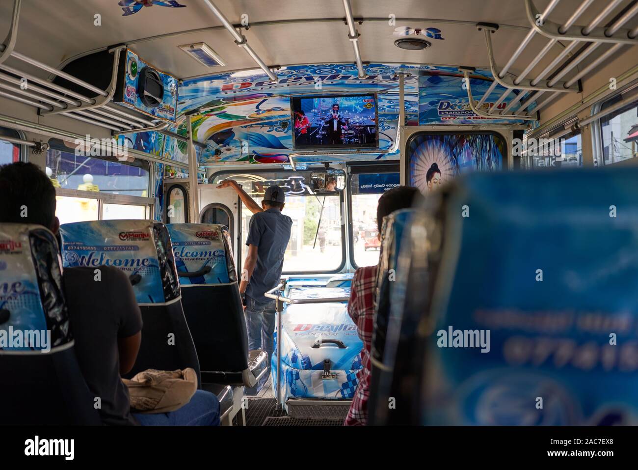 A typical public transport scene in Colombo, the conductor is keeping an eye out for potential passengers Stock Photo