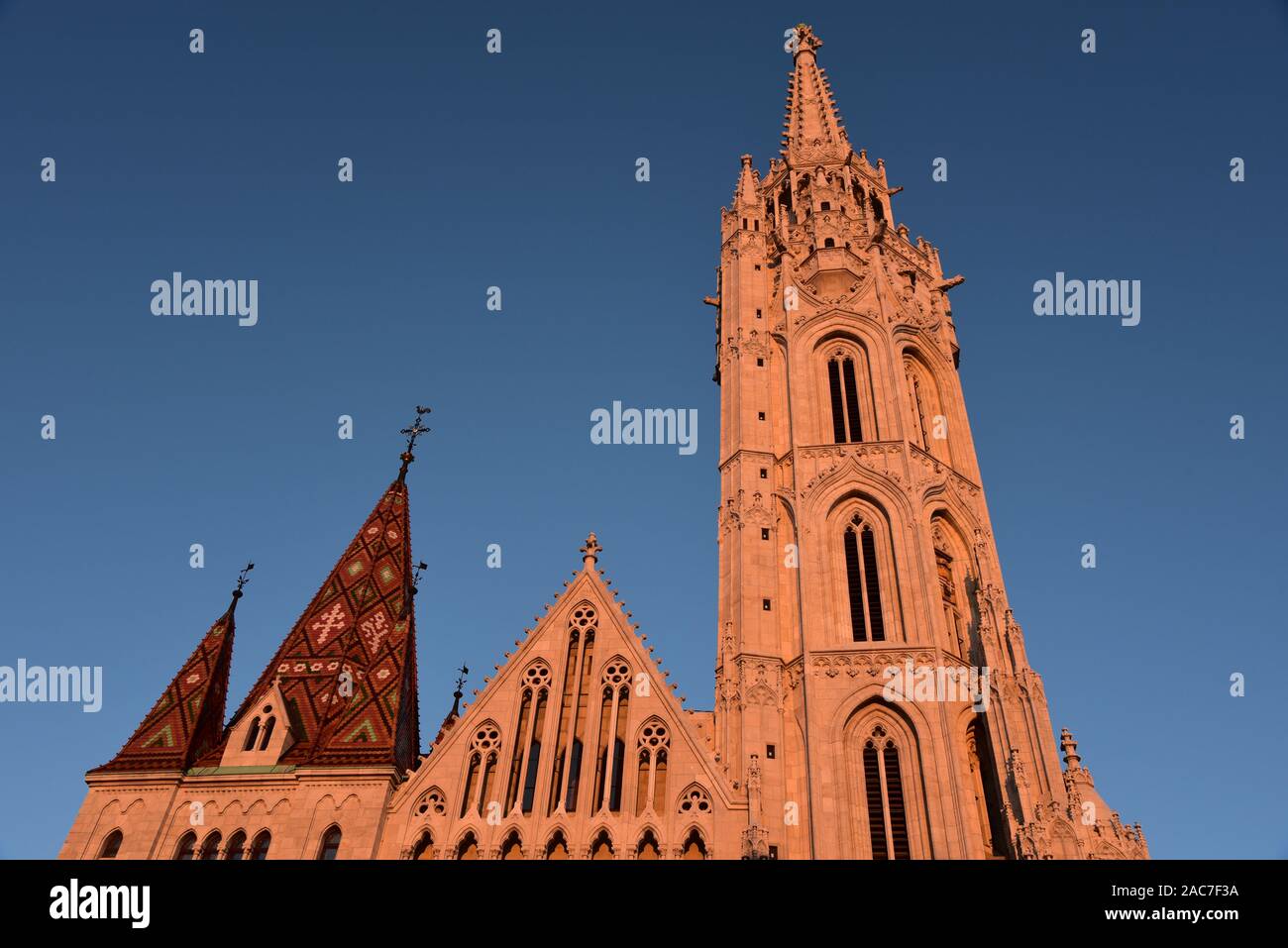 The spire and rooftop of Mátyás Church bask in the glorious late afternoon sun, Castle District, Budapest, Hungary, Europe. Stock Photo