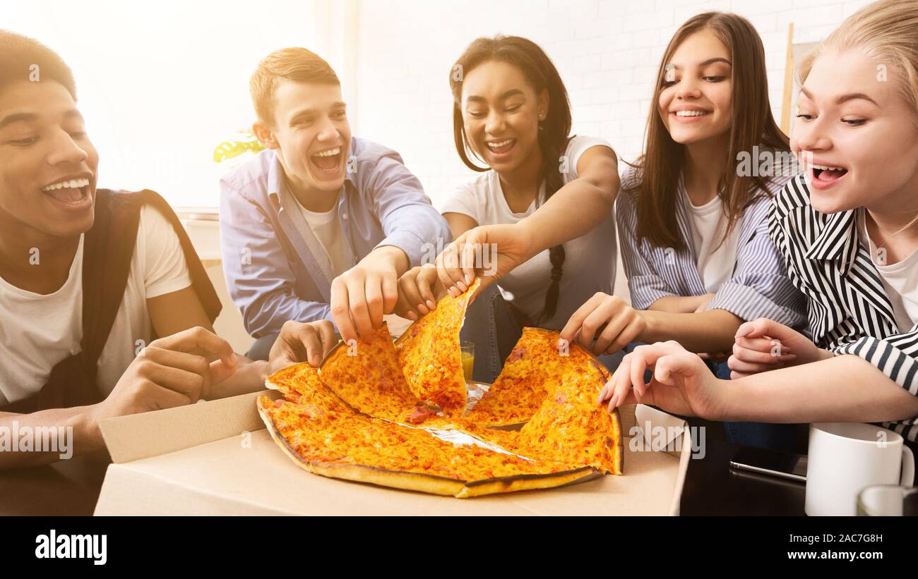 Lunch delivery. Friends taking pizza slices, panorama Stock Photo