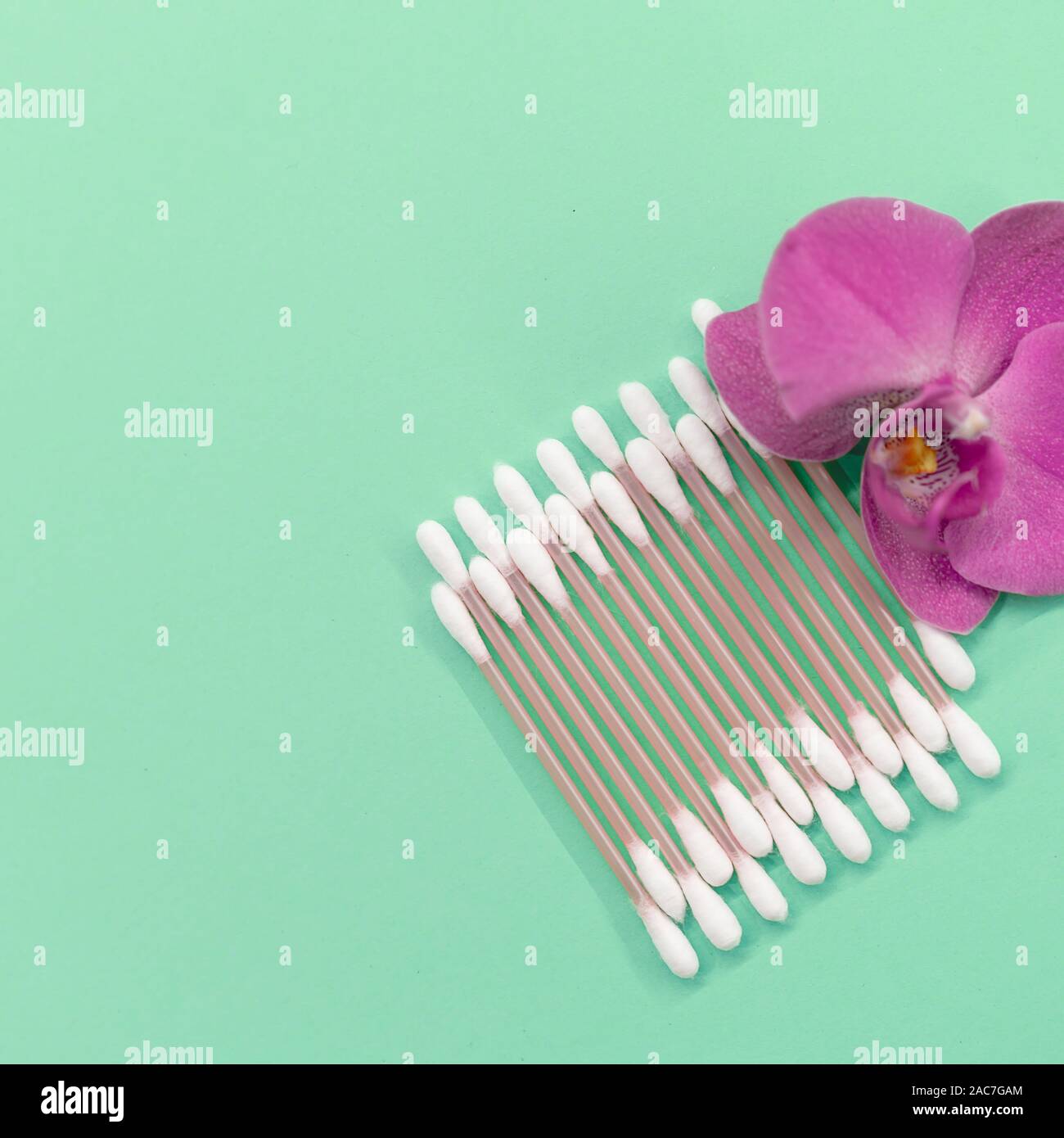cotton buds, pads on a mint background. Orchid flower. Eco-friendly. Concept cosmetics Stock Photo