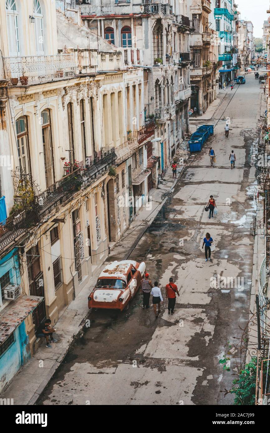 Havana, Cuba - October 18, 2019: Local people in the streets of Old Havana/Cuba with its colourful houses and American classic cars. Stock Photo