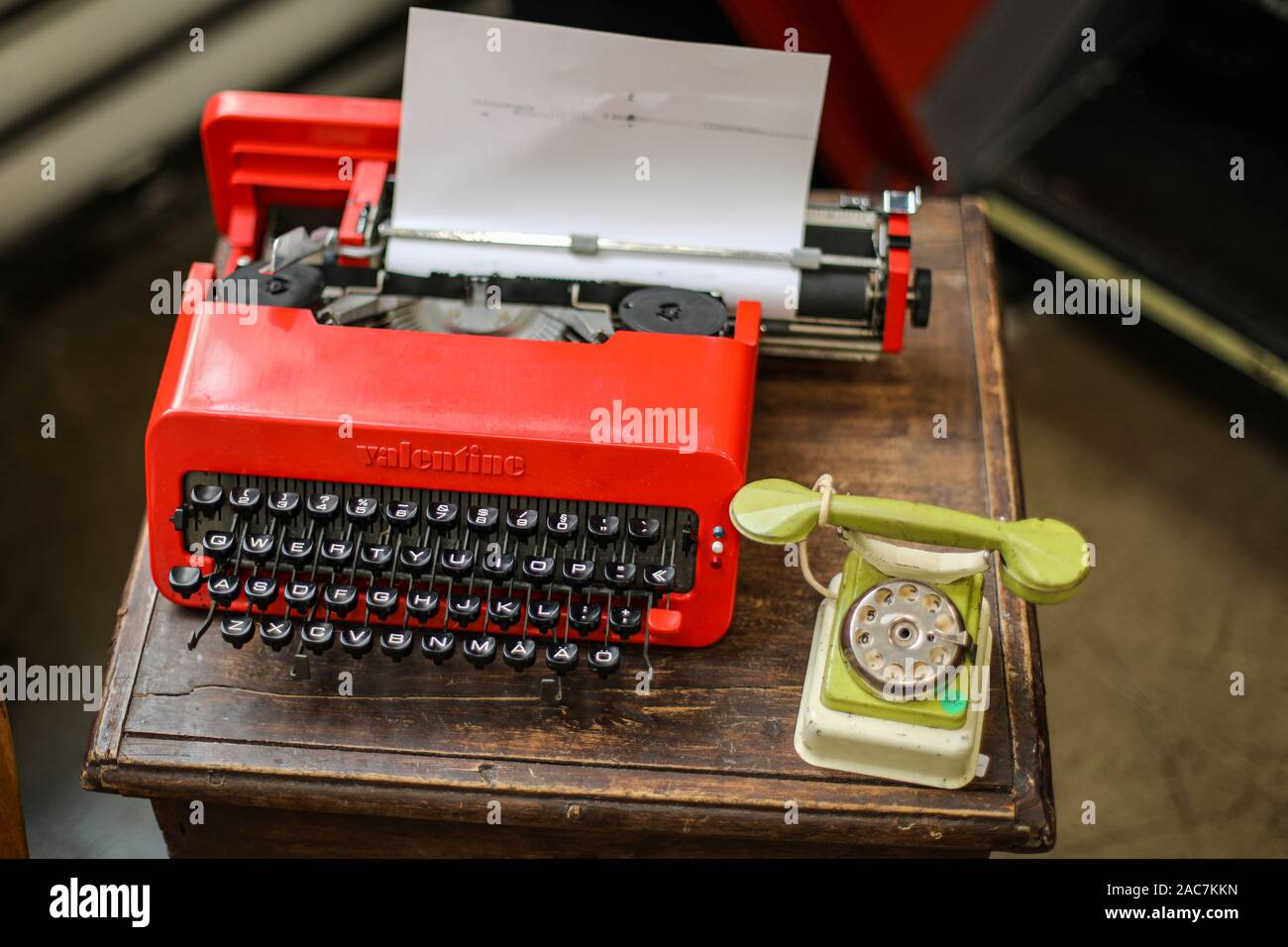 Red plastic manual Valentine typewriter and green tin toy landline phone at Helsinki Retro and Vintage Design Expo Stock Photo