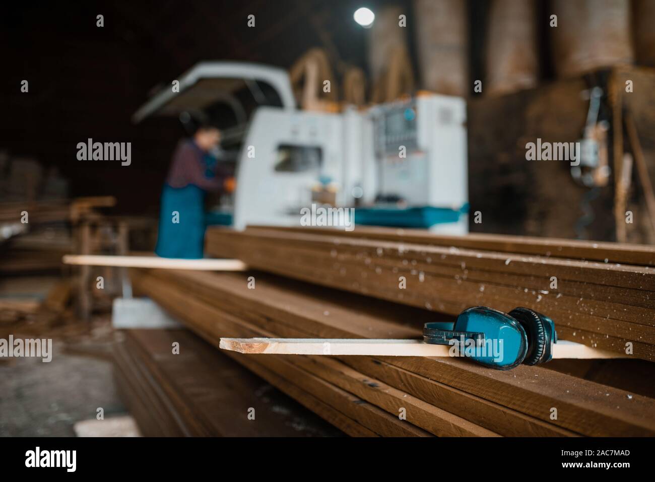 Stack of boards, carpenter at woodworking machine Stock Photo