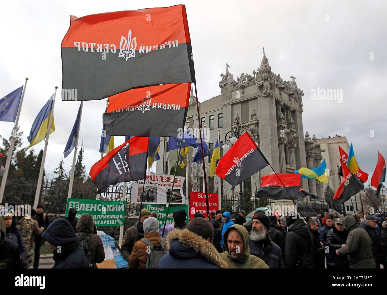 Ukrainian activists from Right sector far-right political party and their supporters hold flags during a rally outside the Presidential Office in Kiev.The activists demand to break the diplomatic and economic relations with Russia and the inadmissibility of any concessions to Russia, during their rally dedicated to the Euromaidan clashes anniversary. The nationalists mark the 6th anniversary of the first and mass clashes protestors with police near the Presidential Administration of President Viktor Yanukovich on 1 December 2013, of the Euromaidan Revolution times. Stock Photo