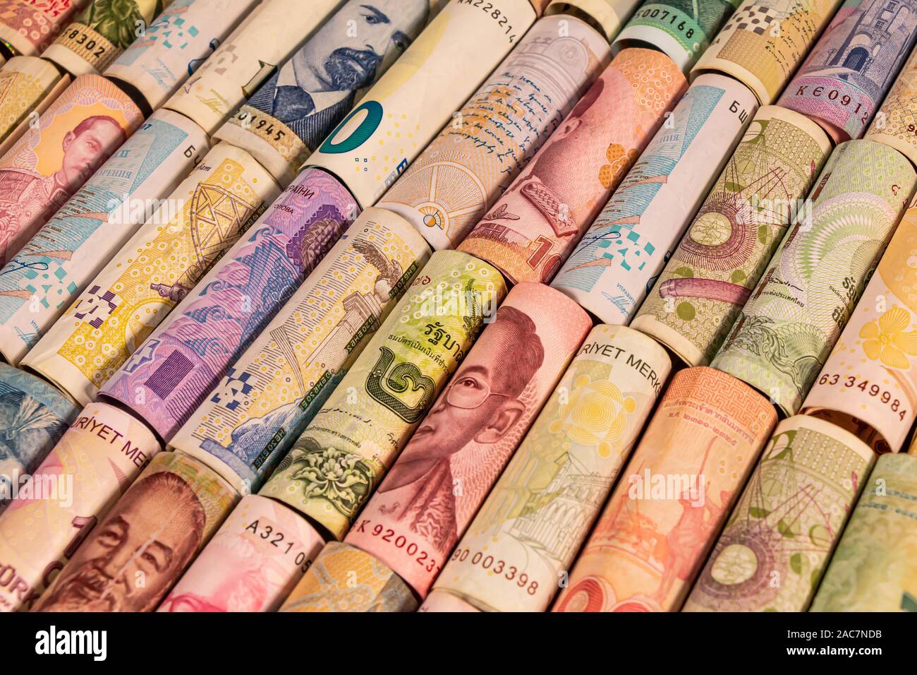 Different colourful banknotes from various countries on rolls to be used for illustrating subjects as business, banking, media, etc. Stock Photo