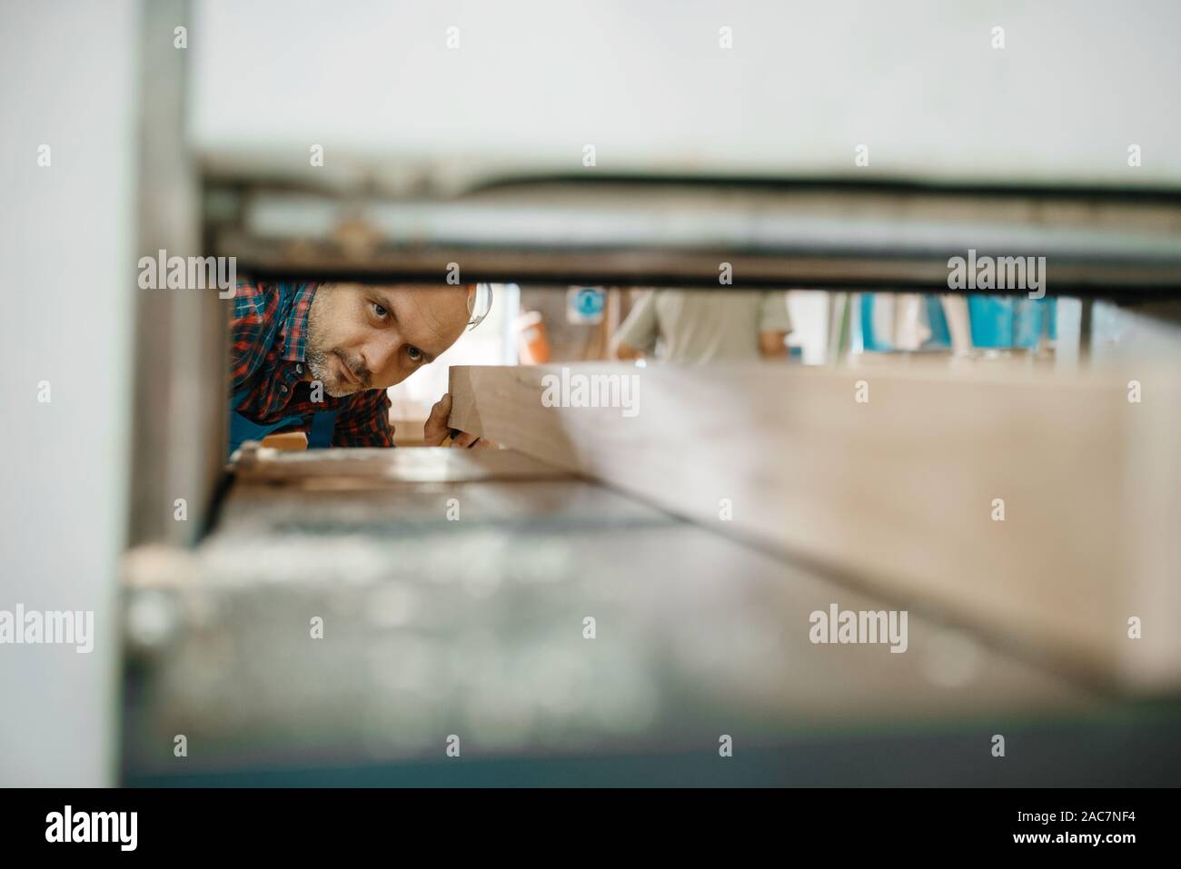 Carpenter works on plane machine, woodworking Stock Photo