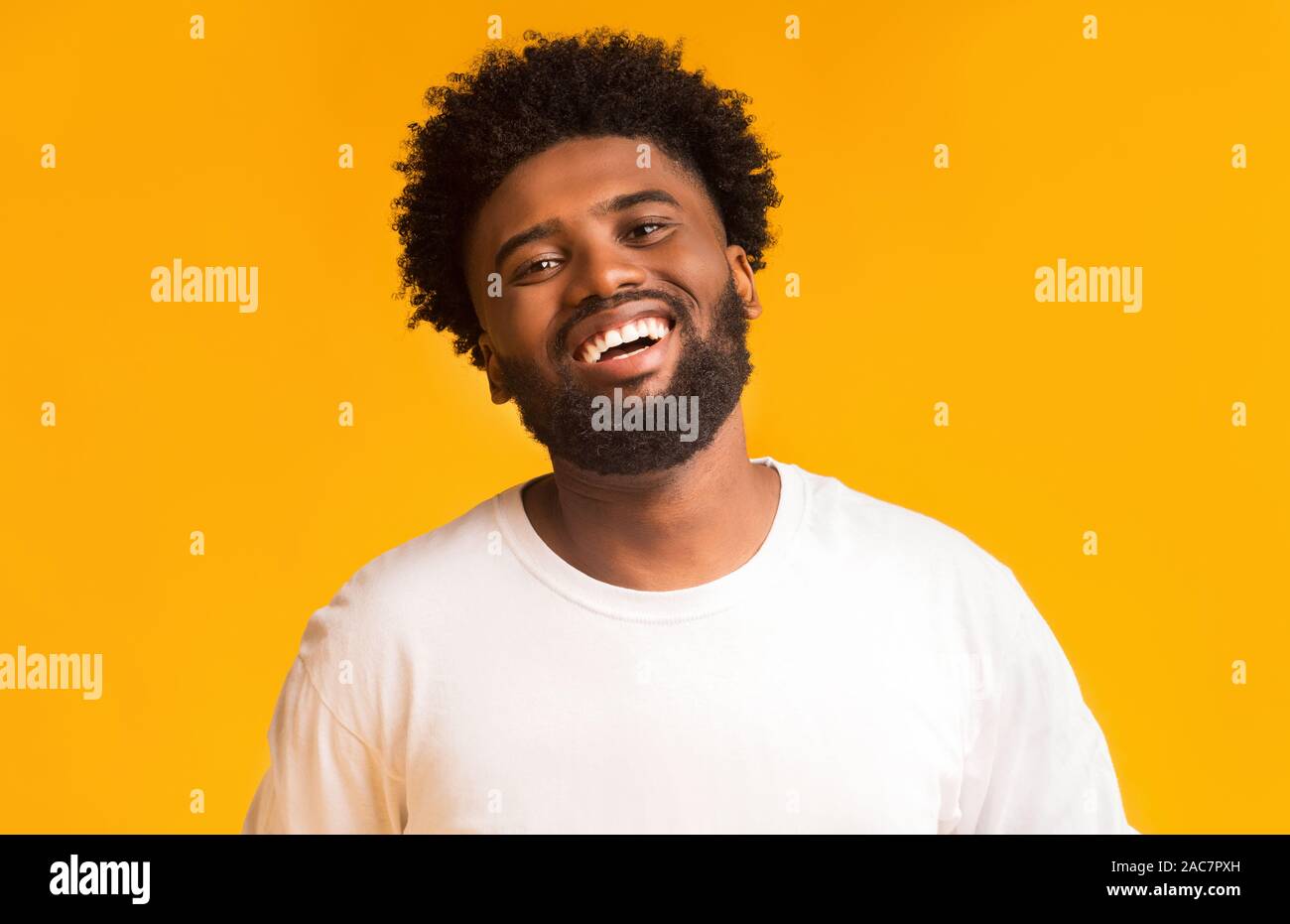 Portrait of laughing black man over orange background Stock Photo