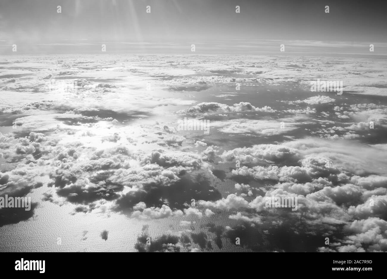 View from plane window. Clouds above water surface. Atmosphere concept. Air pollution