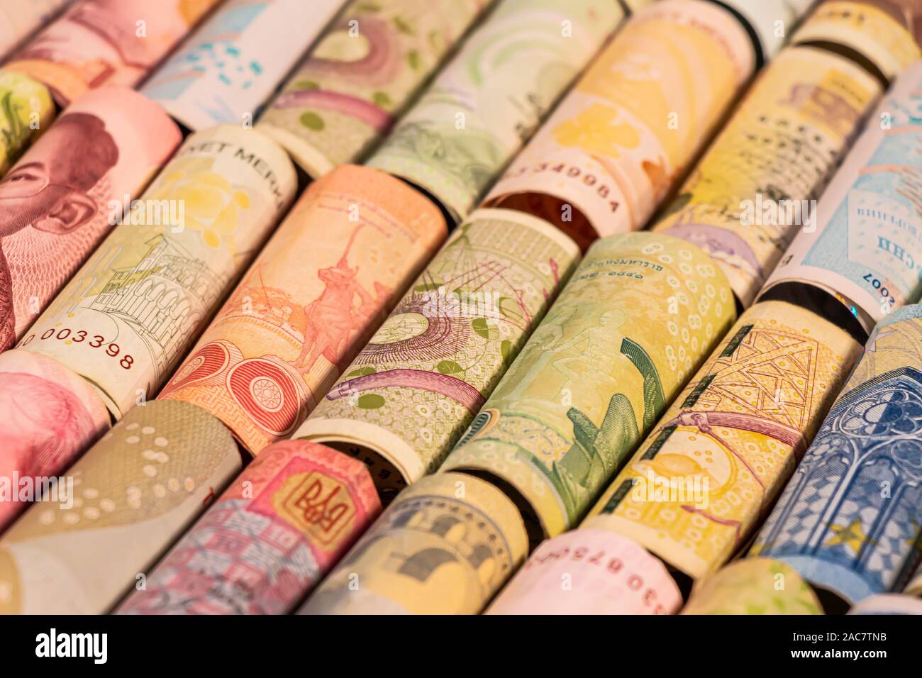 Different colourful banknotes from various countries on rolls to be used for illustrating subjects as business, banking, media, etc. Stock Photo