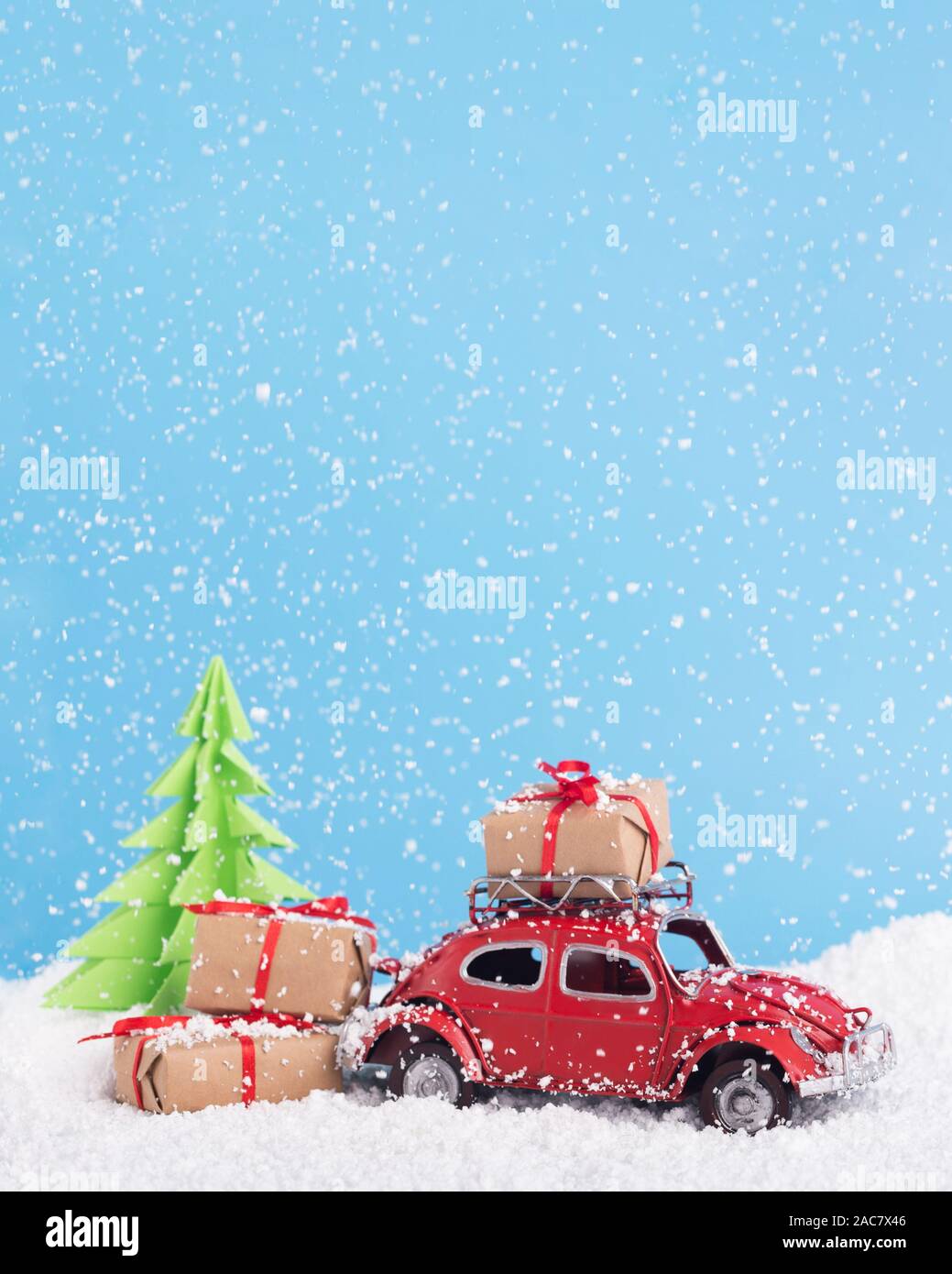 Retro car Volkswagen Beetle with presents and tree on snowy background Stock Photo