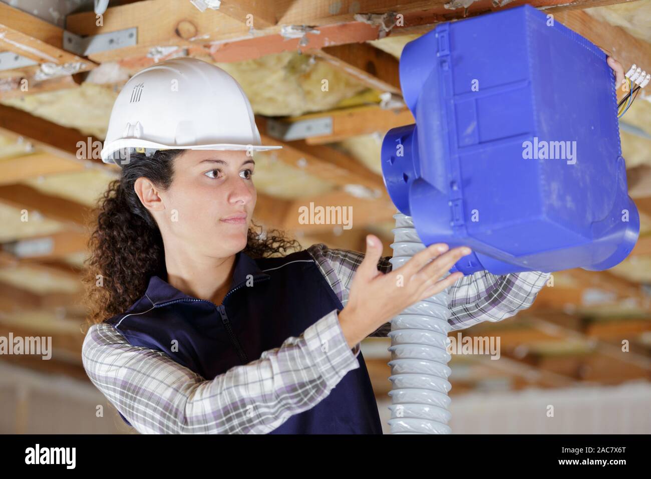 young female worker installing plastic ventilation unit Stock Photo Alamy