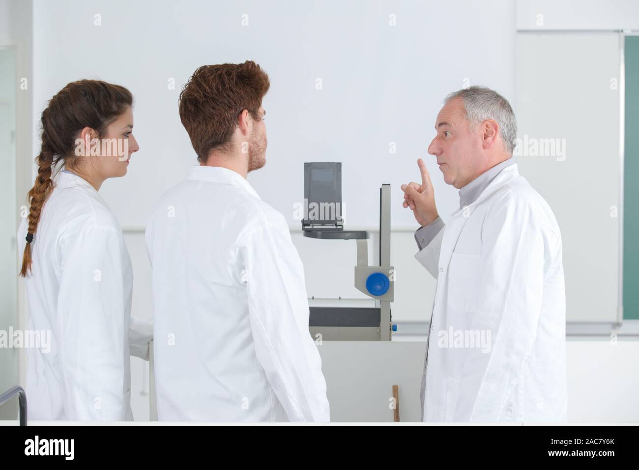 teacher pointing students attention towards projector screen Stock Photo