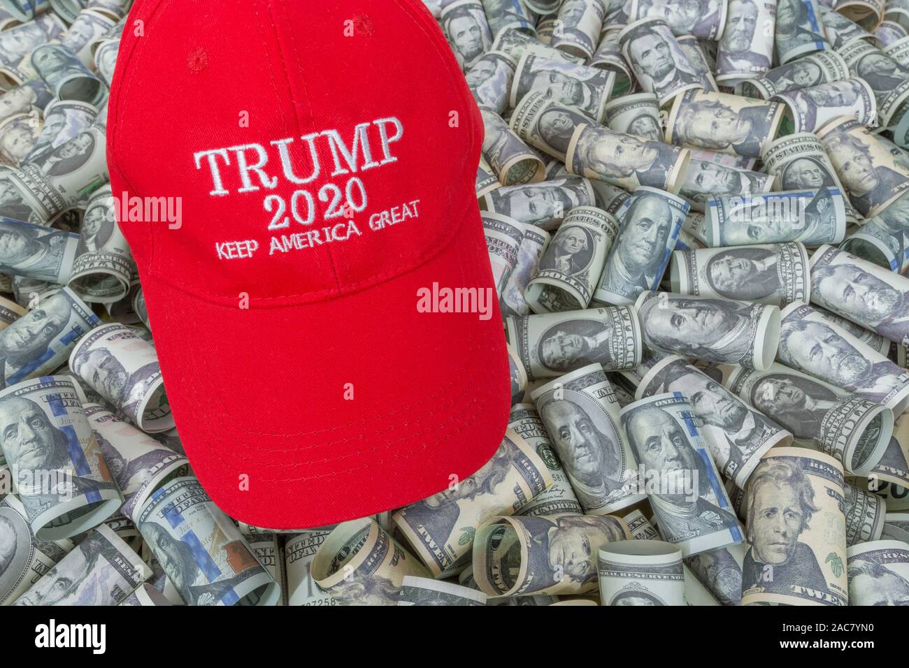 Red Trump KAG / Keep America Great cap hat + Dollar bills (See NOTES). For booming U.S. economy / the Trump Economy, Trump tax cuts, 2020 US Election. Stock Photo