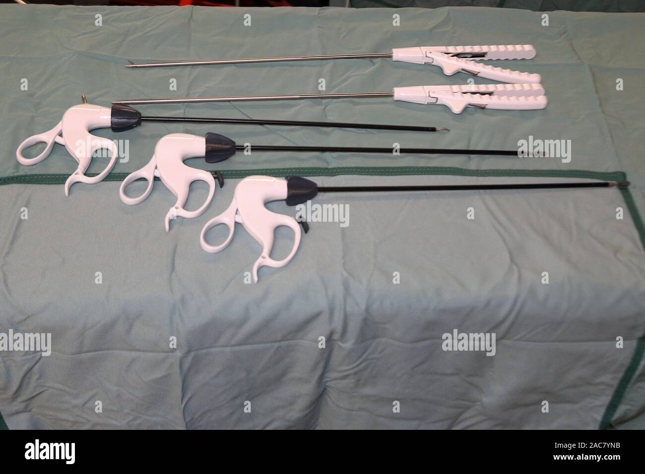 A few single use laparscopic (Key hole) surgey instruments on a green surgical drape Stock Photo
