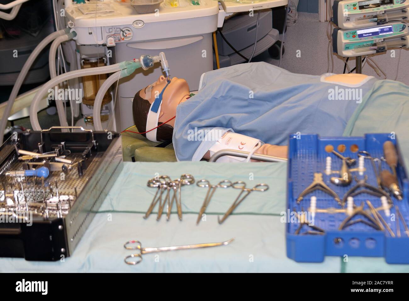 a simulated operation showing a patient (manakin) and an anaesthetic machine in the background and surgical instrumentation in the foreground Stock Photo