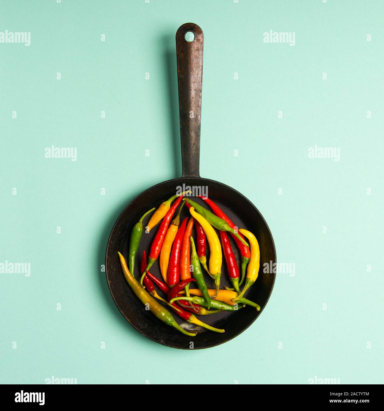 Fresh Red Orange And Green Hot Chilli Peppers On A Vintage Frying Pan Studio Shot Isolated On Mint Background Stock Photo Alamy