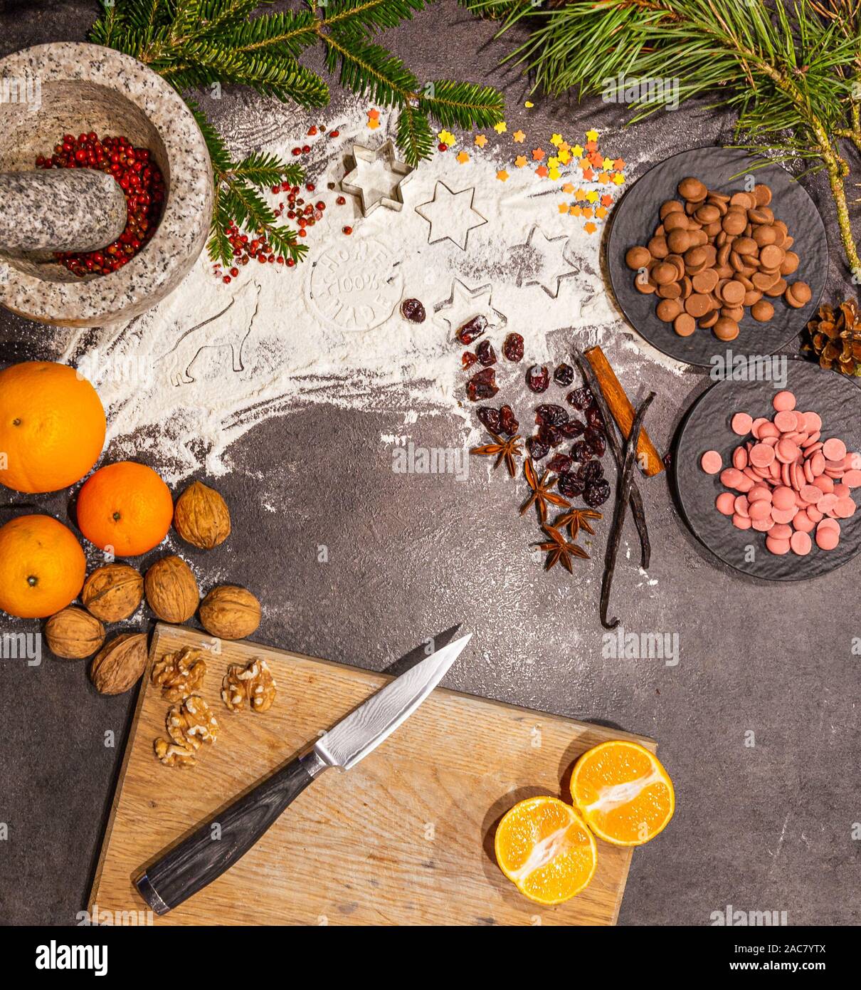 Delicious and beautiful handmade flat lay for christmas baking with chocolate chips, oranges, nuts, cinnamon cranberries vanilla and other decoration. Stock Photo