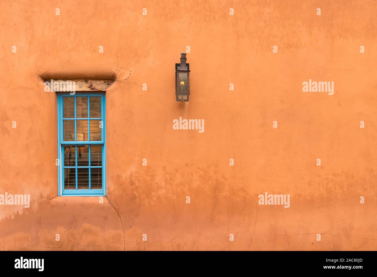 Old Southwestern Brown Adobe Wall with Window and Lantern Stock Photo