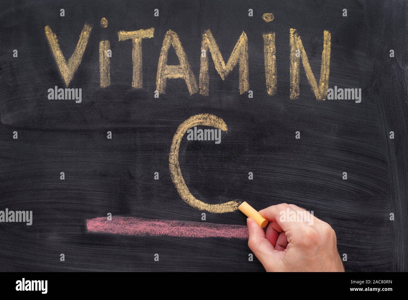 Man writing words Vitamin C on chalkboard. Vitamin C Concept. Close up. Stock Photo