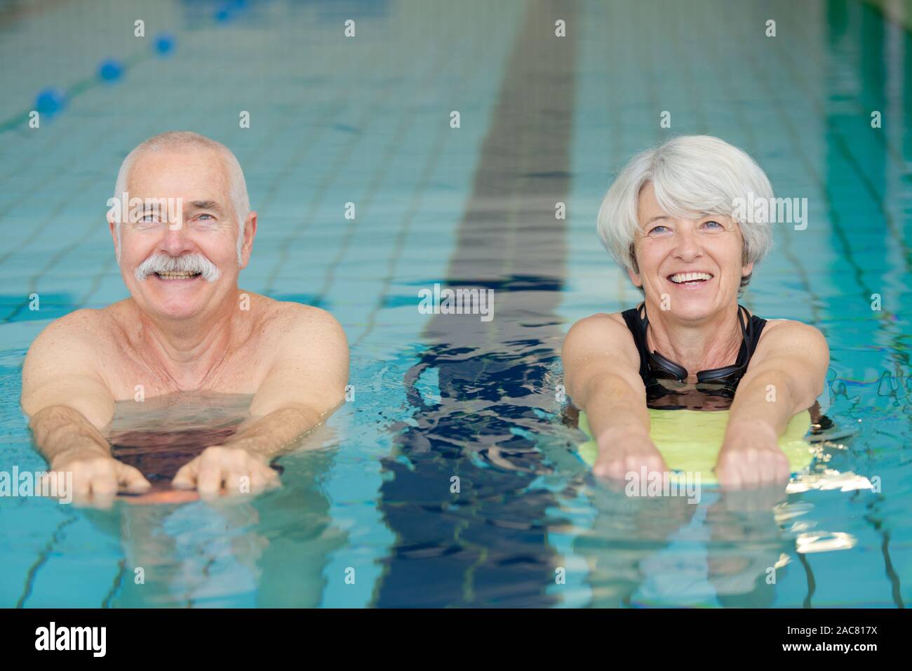 happy senior couple taking swimming lessons Stock Photo