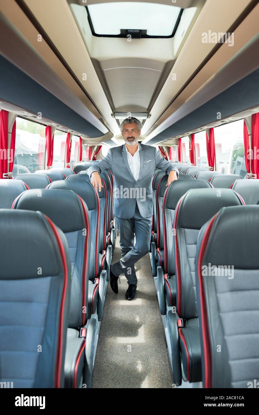 suited senior man stood in empty coach Stock Photo