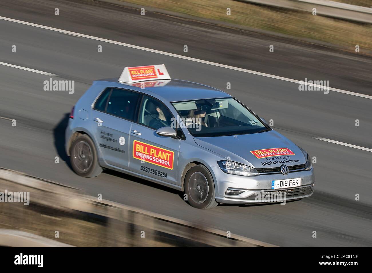 Blurred moving car Bill Plant Driving School  traveling at speed on the M61 motorway Slow camera shutter speed vehicle movement Stock Photo