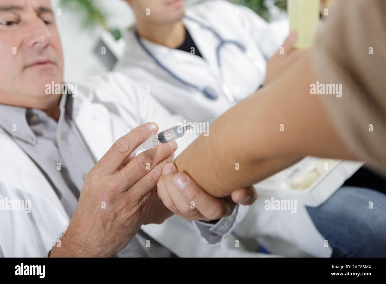 Patient Arm Injection doctor making an injection on patients arm Stock Photo - Alamy