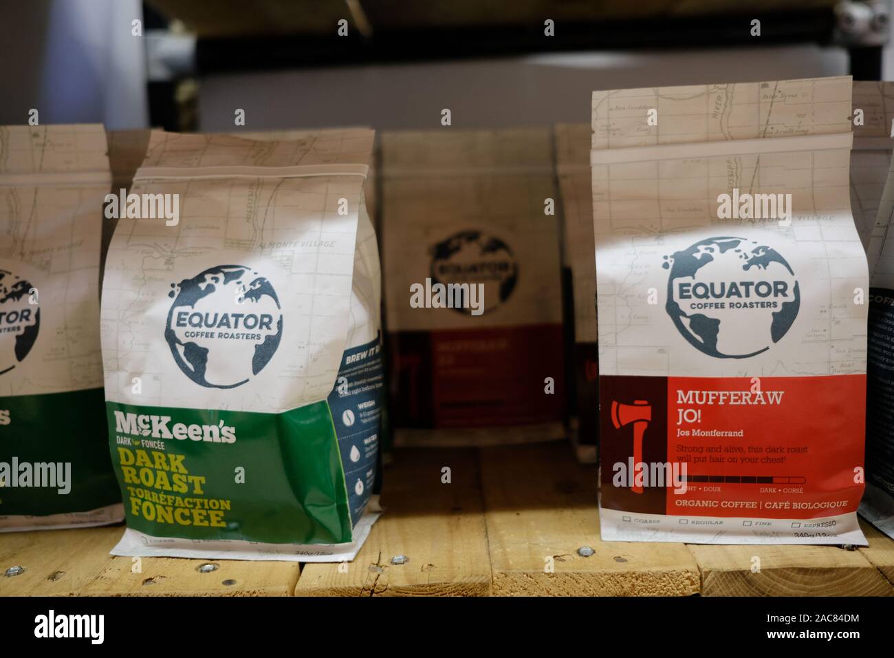 Packets of Equator coffee on a wooden shelf at the local grocery store