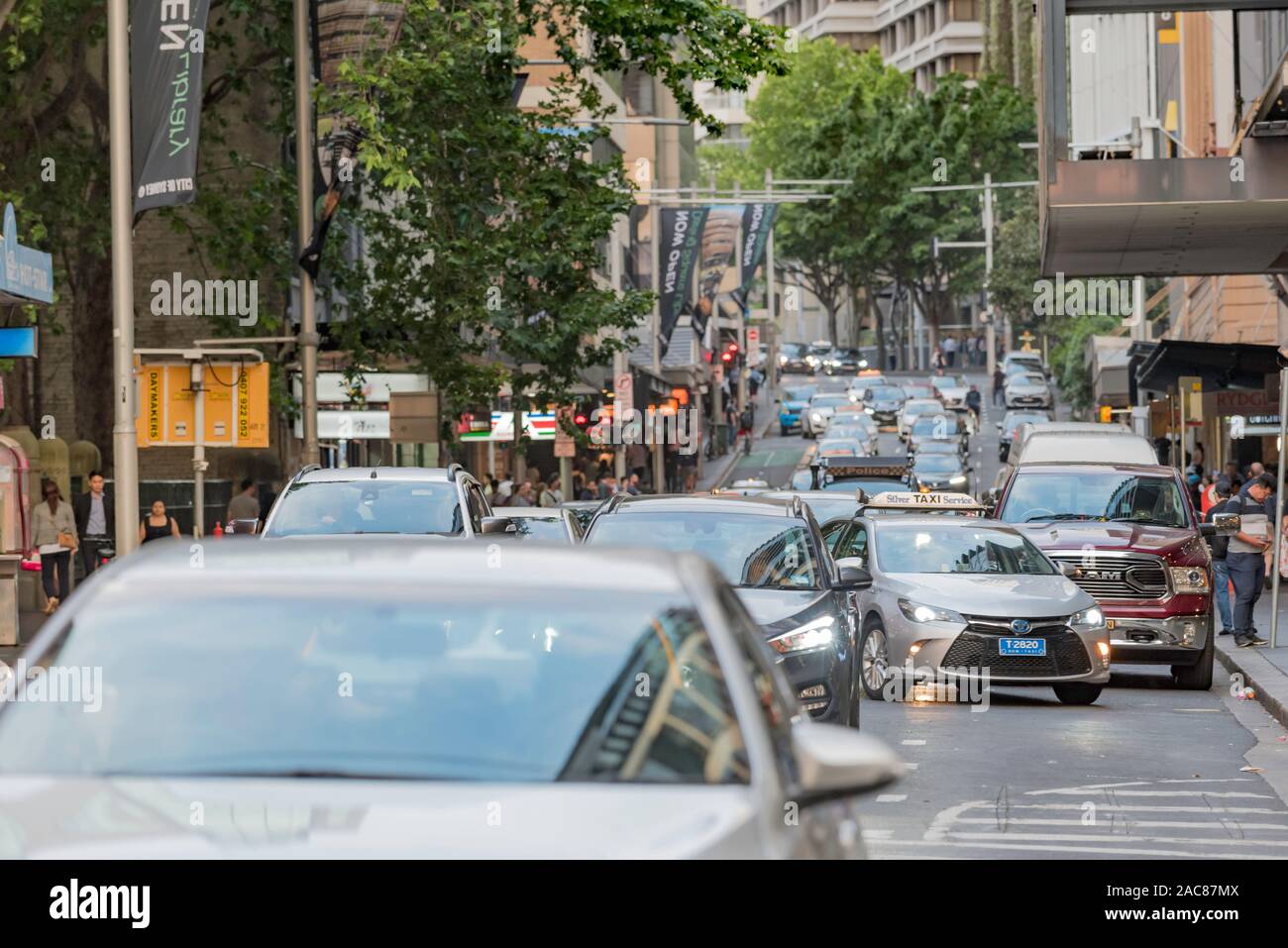 Cars manoeuvring in peak hour traffic in an inner city Sydney street on a Spring evening in Australia Stock Photo