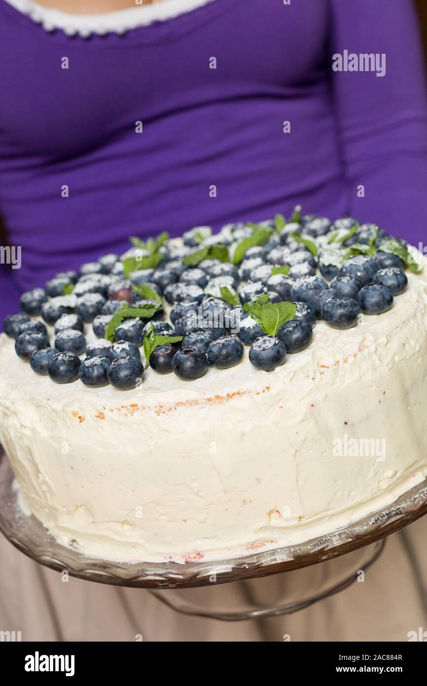 Woman In A Lilac Shirt Holding A Homemade Birthday Cake With Fresh