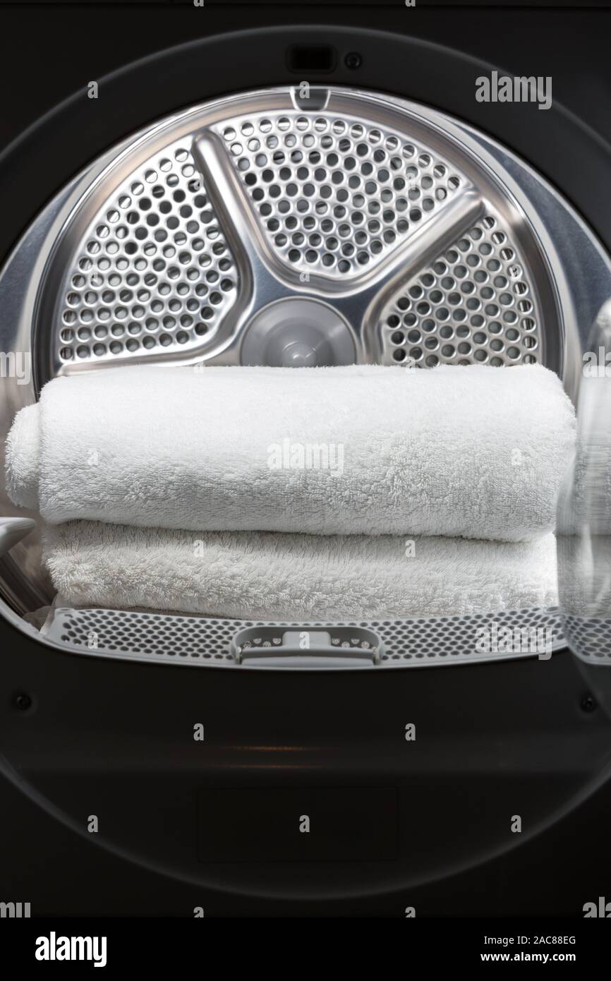 Stacked clean white towels inside washing machine drum. Clean concept