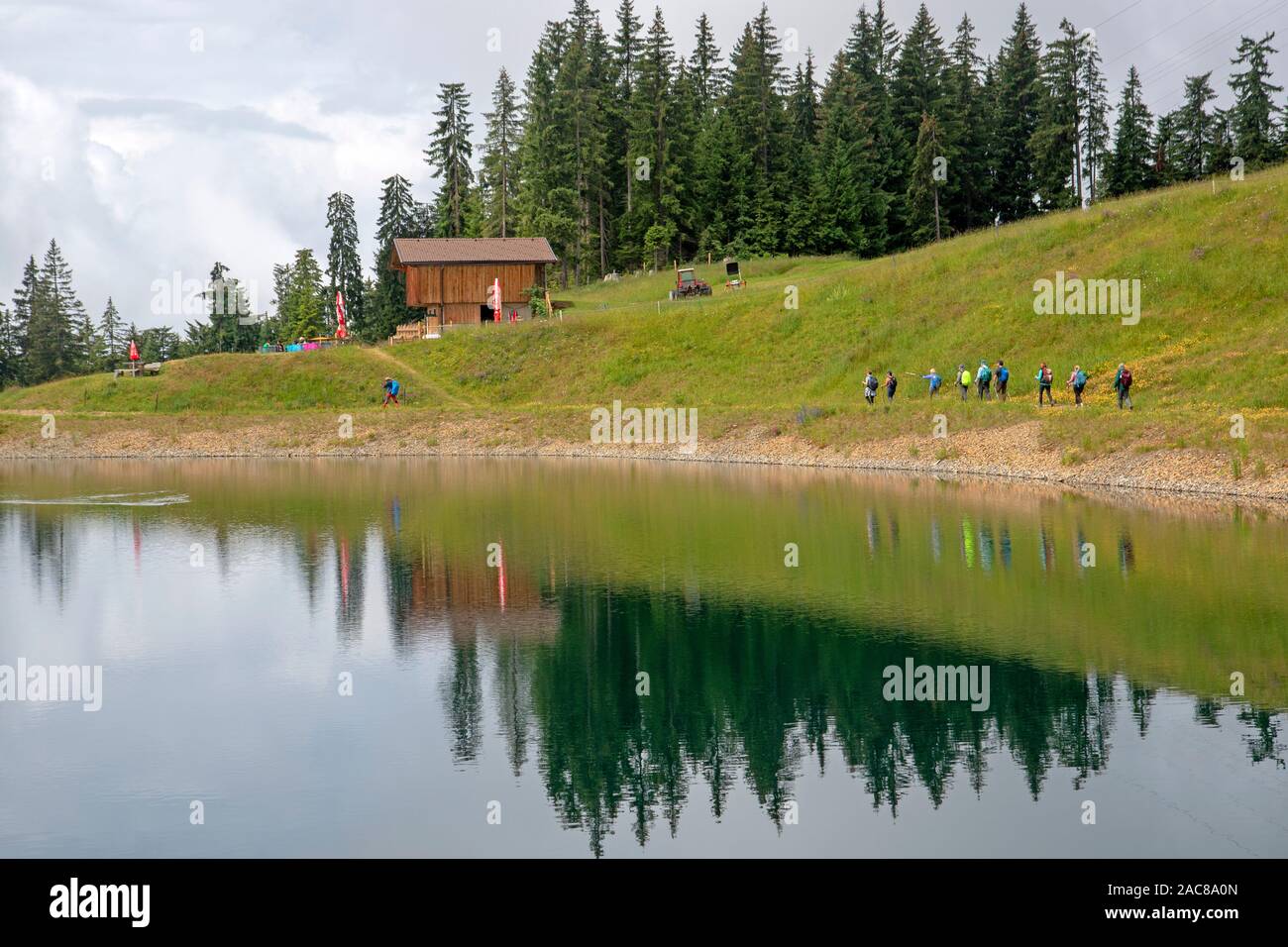 Hikers on the shores of a lake on the slopes of Hohe Salve Stock Photo