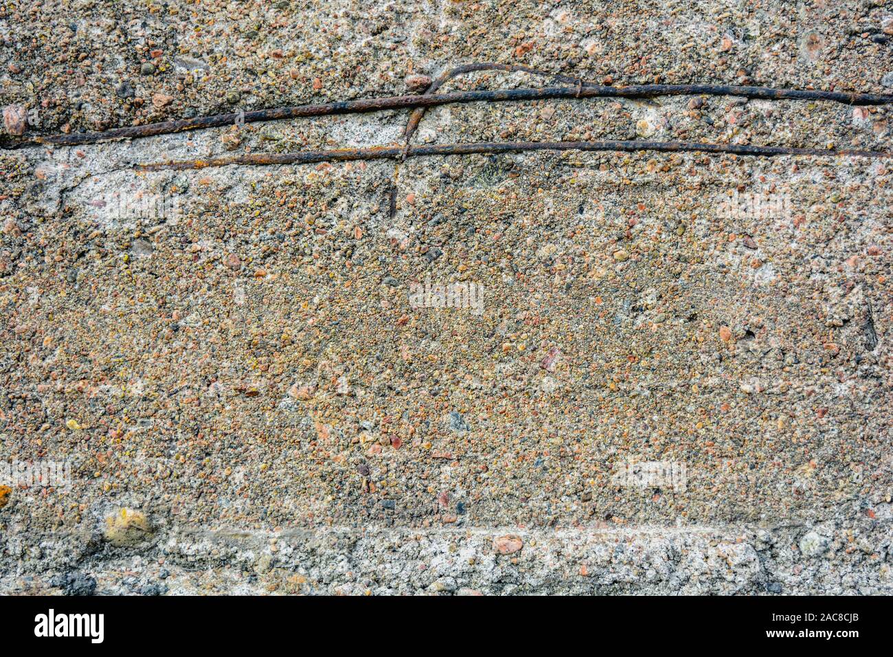 Texture of crumbling concrete wall with horizontal bars of rusty iron