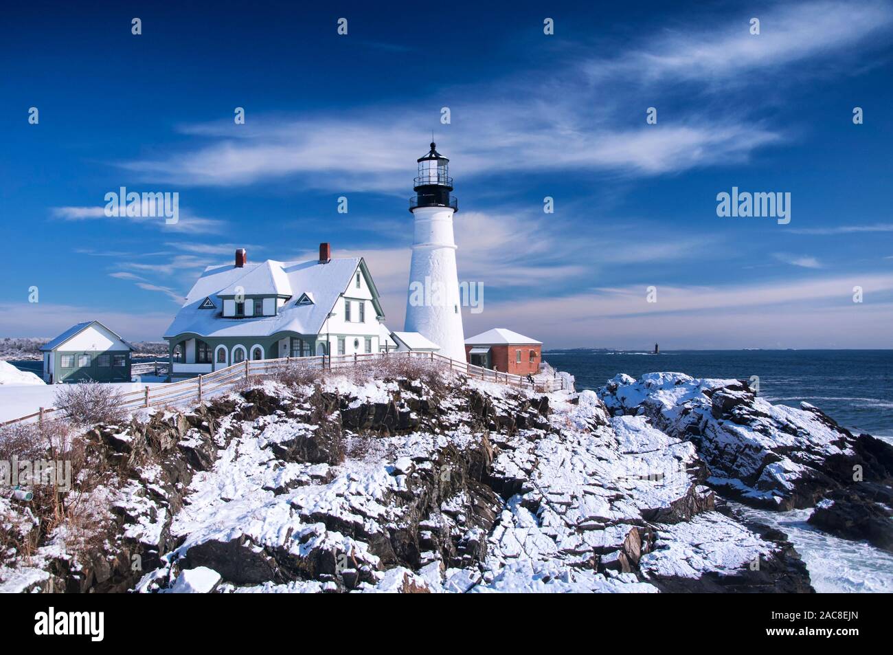 the iconic landmark Portland Headlight after a winter storm in Portland Maine on a sunny blue