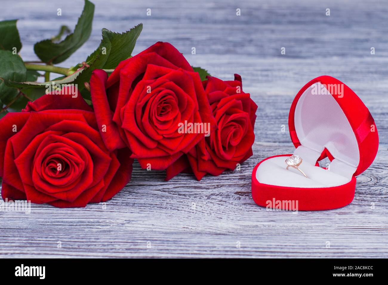 Diamond ring in heart shaped box with flowers. Stock Photo