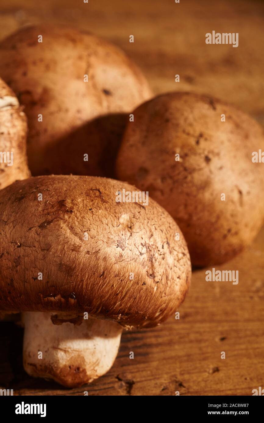 raw, fresh, whole crimini mushrooms on a wood background Stock Photo