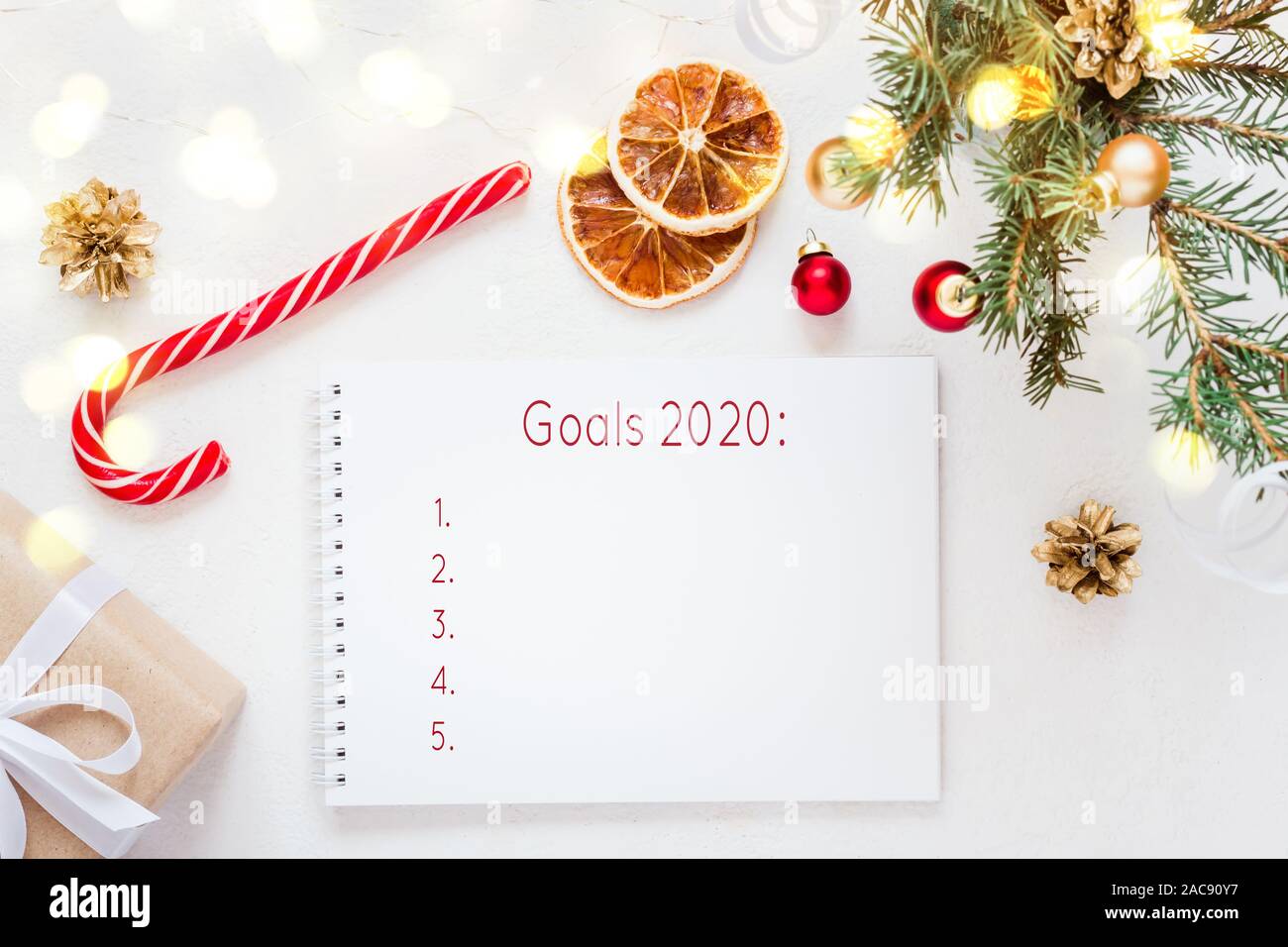 Notebook With Wish List And Christmas Decorations And Light Garland On White Table Stock Photo Alamy
