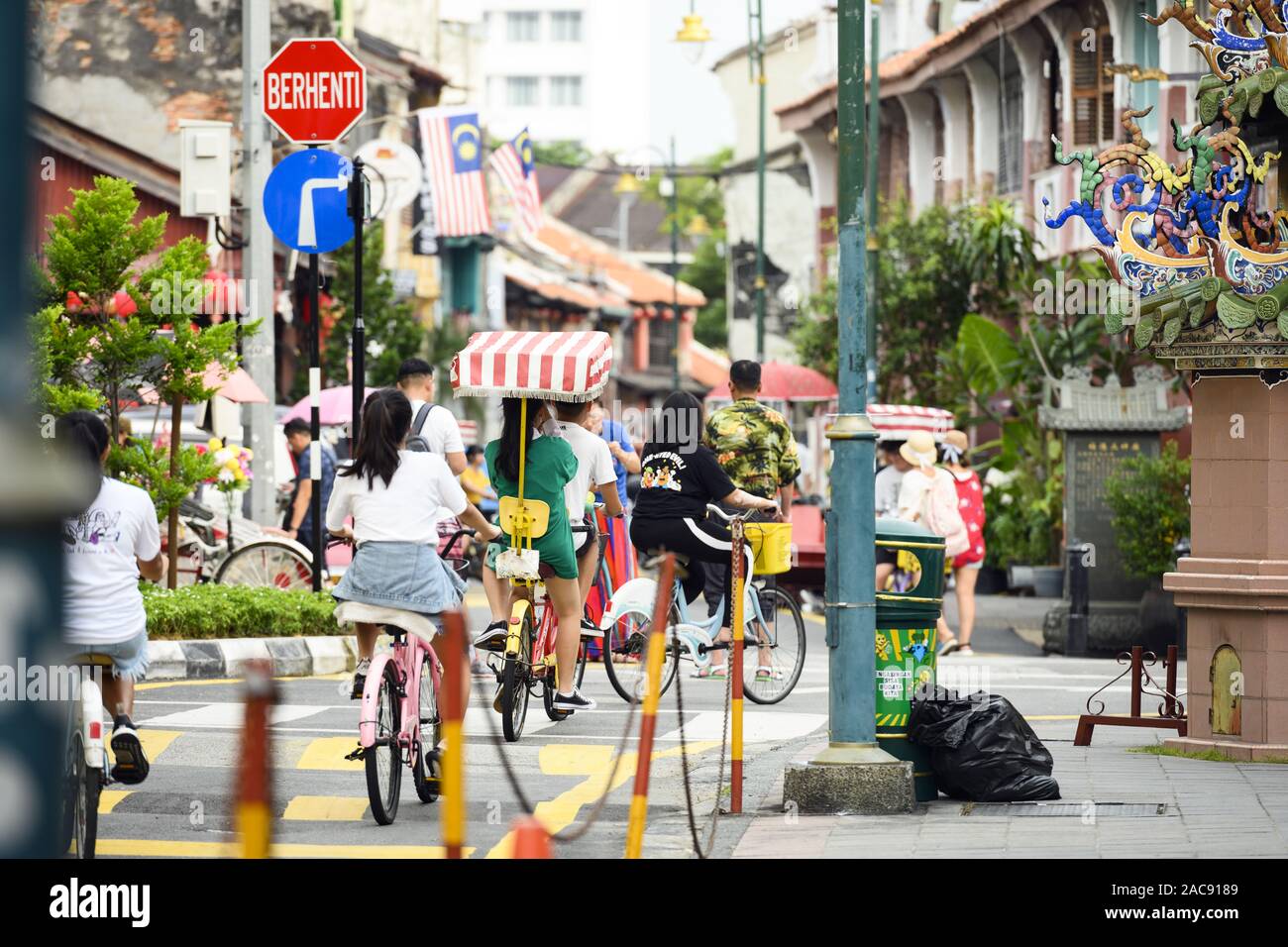 Some tourists are walking and cycling in Armenian Street in George Town. Stock Photo