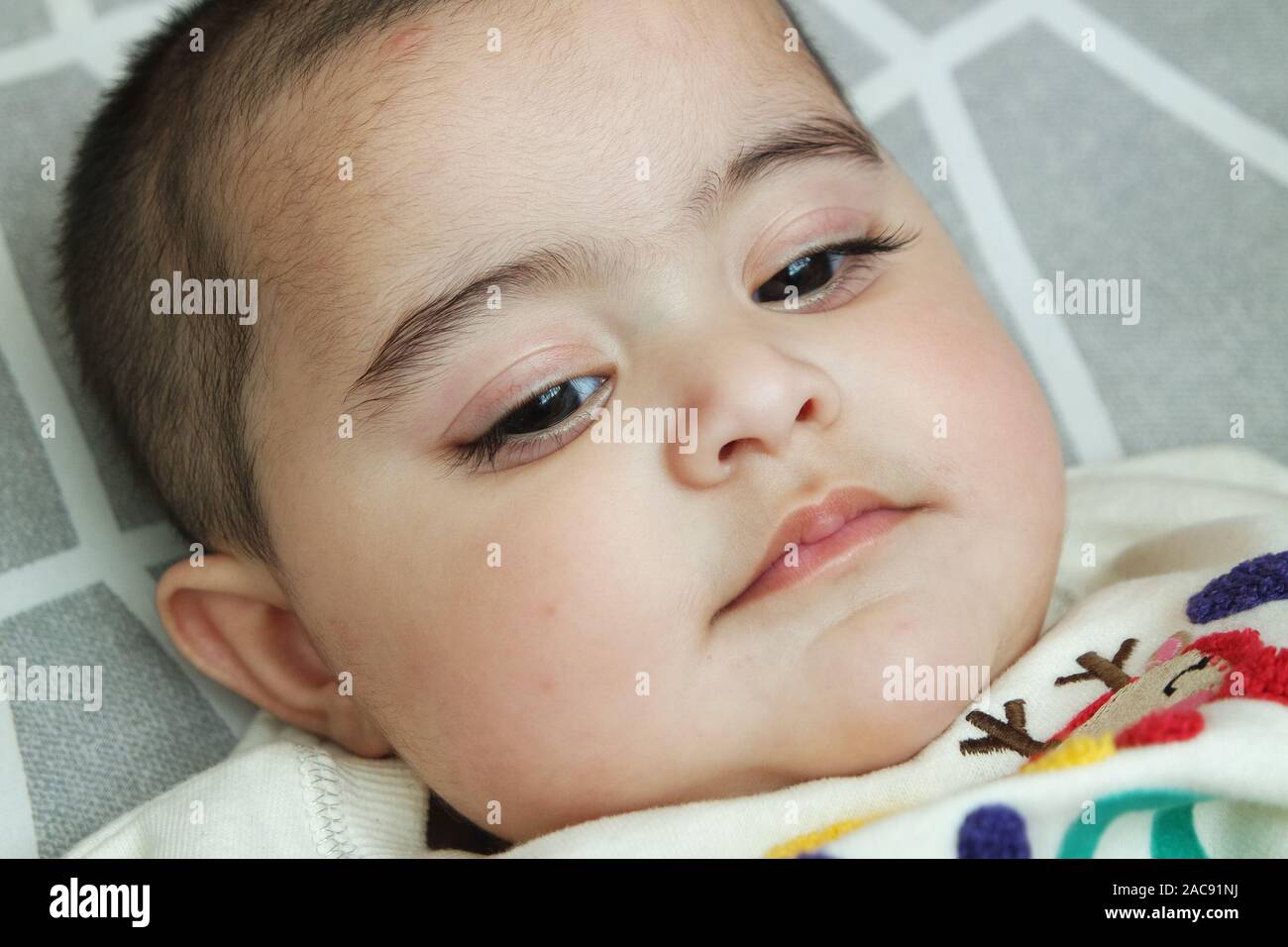 Portrait of a baby girl with a smiling face, big eyes, and lovely face gesture Stock Photo