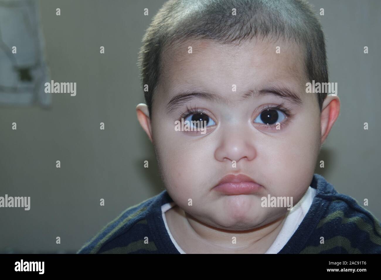 Portrait of a baby girl with a smiling face, big eyes, and lovely face gesture Stock Photo