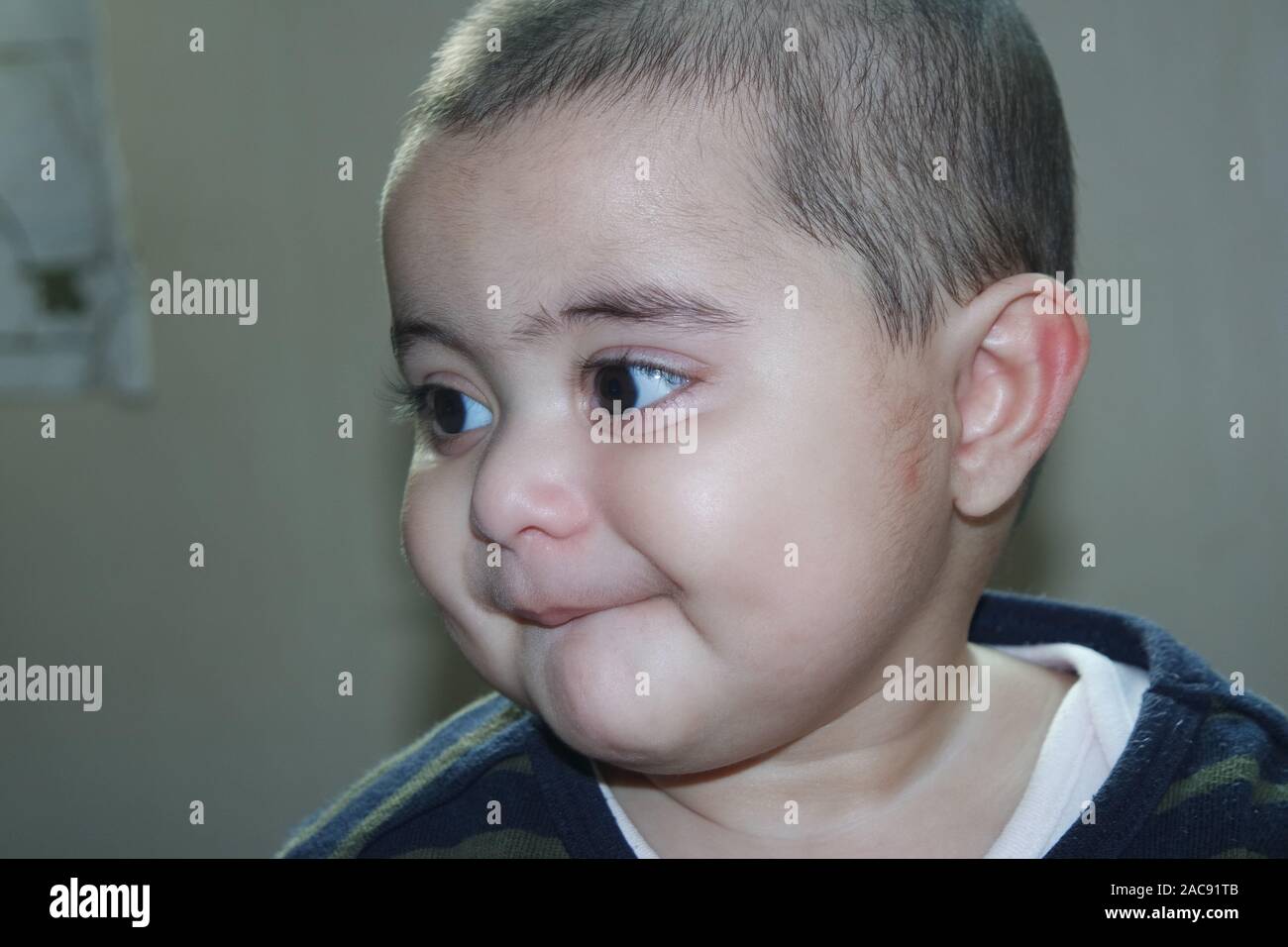 Portrait of a baby girl with a smiling face, big eyes, and lovely face gesture Stock Photo